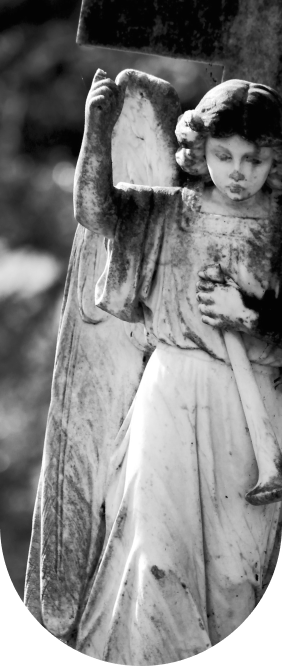 Weathered marble child angel holding a trumpet before a stone cross